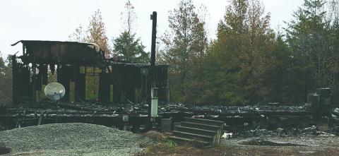 The remains of a burned-out doublewide off  County Road 28 were still smoldering Monday morning after an allegedly deliberate fire was set at the residence Sunday night.