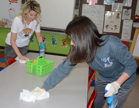 Haleyville Elementary Media Specialist Jennifer Haughton, left, and First Grade Teacher Robin Wilson clean desks and tables in classrooms while the school is closed.