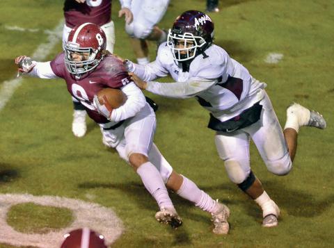 Austin Barry is on a carry for the HHS Lions, with Hamilton’s Jathan Jackson holding on to Barry’s jersey.