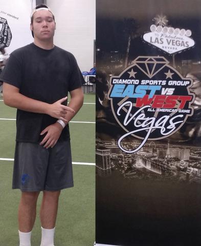 Bradley stands next to the Elite All- American football sign that was  displayed while he was playing in  Atlanta.