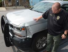 Bear Creek Police Chief Shane Whitten shows some of the damage to his vehicle after it was rammed by the suspect vehicle during a chase.
