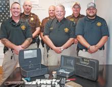 Winston County Sheriff Horace Moore and his deputies with drugs, a gun and paraphernalia recovered during the recent arrest of a major drug supplier.  From l-r:  Chief Deputy Caleb Snoddy, Deputies Jonathan Oliver and Tim Williams, Moore, Deputy Chris Franks and Investigator Jacob Eward.  Not shown is Investigator Matt Roberts (Courtesy photo) 
