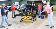 Members of the board of directors look at a Stryker Corporation stretcher.