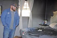 Clay Hall looks at where he believes a fire was set on the bed in his bedroom, where he also discovered a 32-inch TV was missing.