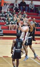 Ben Lowman nearly gets his head pulled off by Gerald Moore, a St. John Paul II Catholic School Falcon, as he goes up for a layup.