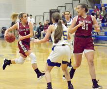 Reagan Kutis drives in for a layup for the Lady Lions. Also shown is Molly Gilbert (21).